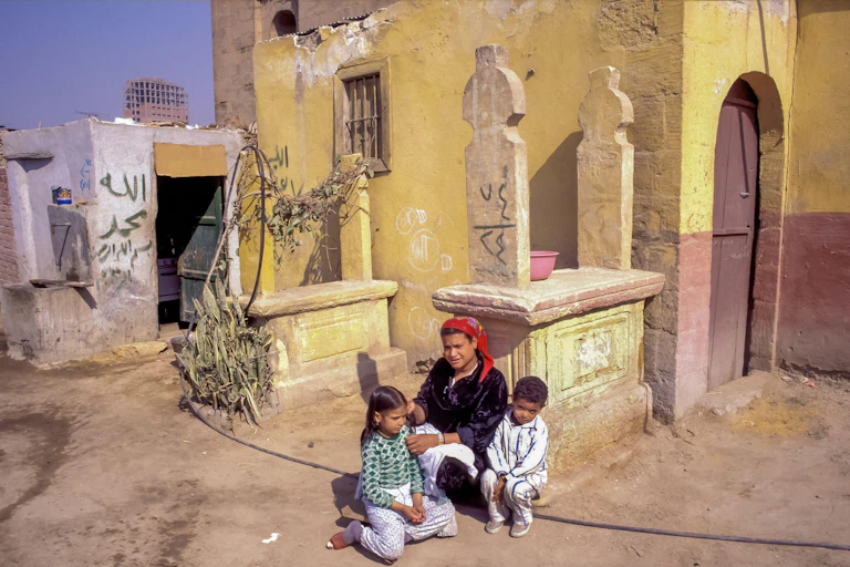 A mother and two children sat on the edge of a wall in the City of the Dead