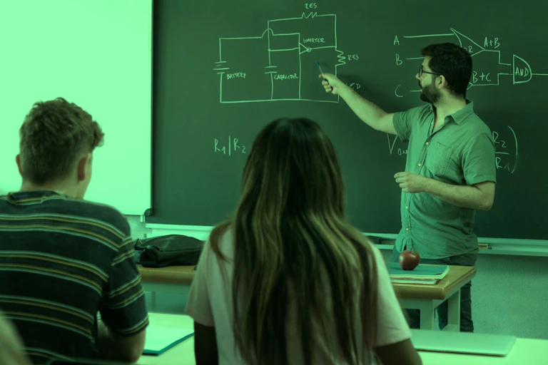 Un profesor señala en una pizarra