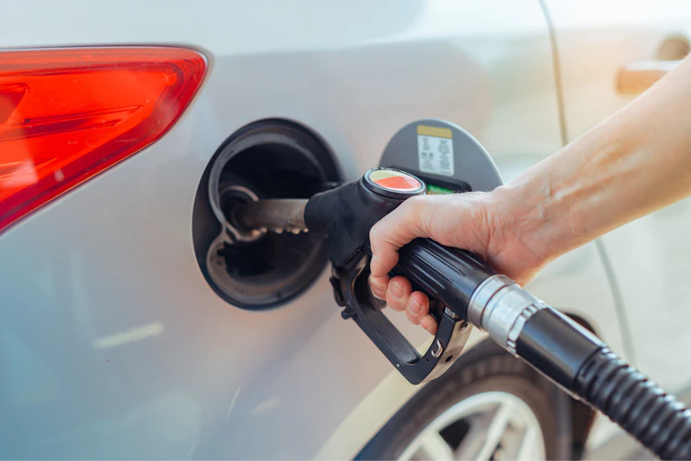 Alguien llena el deposito de combustible de un automóvil.