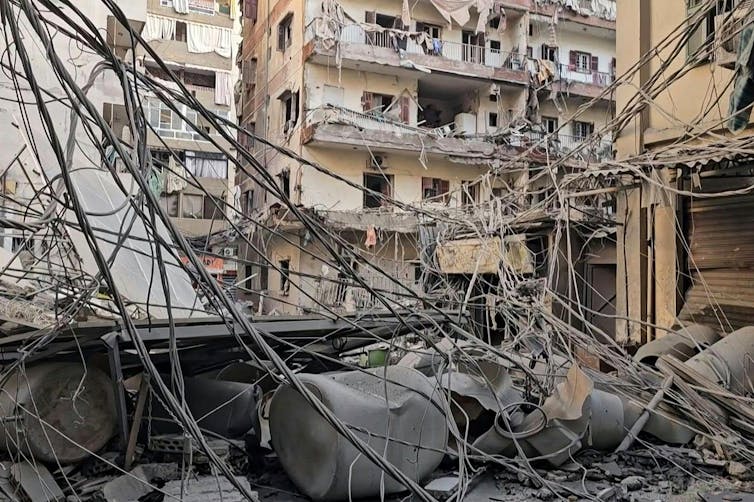 A rubble-filled street in the middle of damaged buildings.