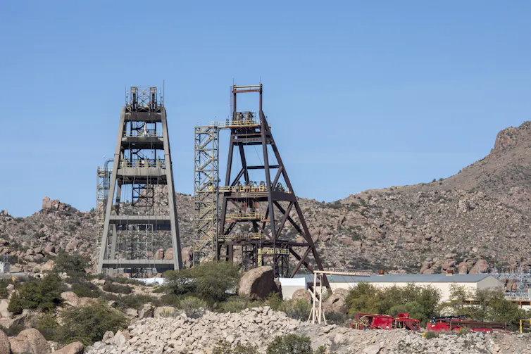 Two large metal frames sit in a rocky landscape.