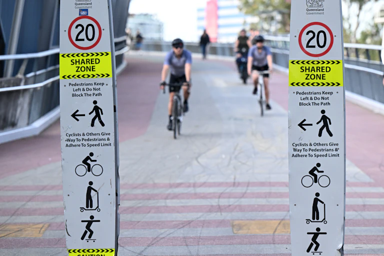 Cyclists are seen riding a bike path in Brisbane.