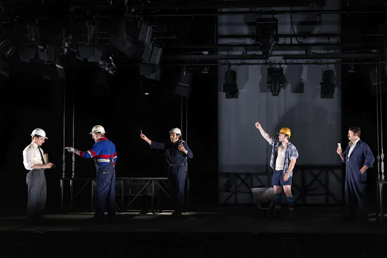Production image: labourers line up in front of a foreman.