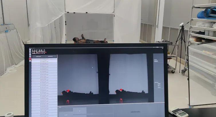 Un homme allongé au sol, visible sur deux images affichées sur l’écran d’un ordinateur portable au premier plan.