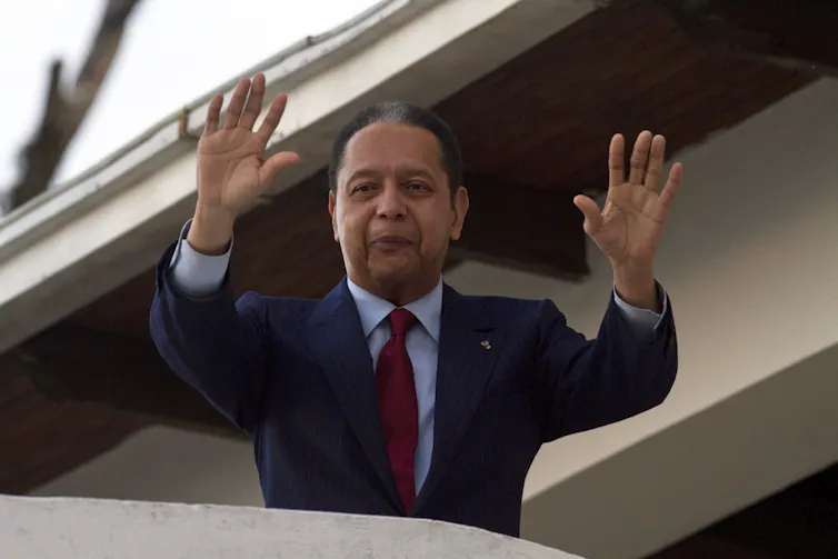 L’ancien dictateur Jean-Claude « Baby Doc » Duvalier salue ses partisans depuis un balcon