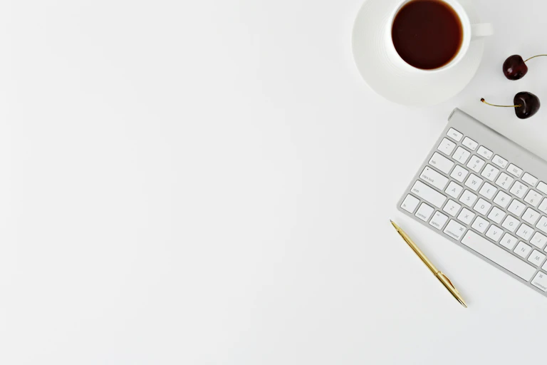 Un bureau avec un clavier et une tasse de café dessus.