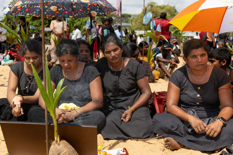 Rising up right through Sri Lanka’s civil battle taught me that obtaining in conjunction with other people throughout divides is a distinctive feature we will be informed 5 Four women in black dresses sit on the sand amid a crowd of people outside.