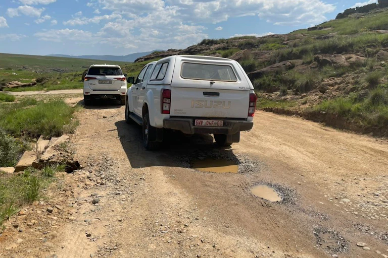 Vehicle on potholed gravel road