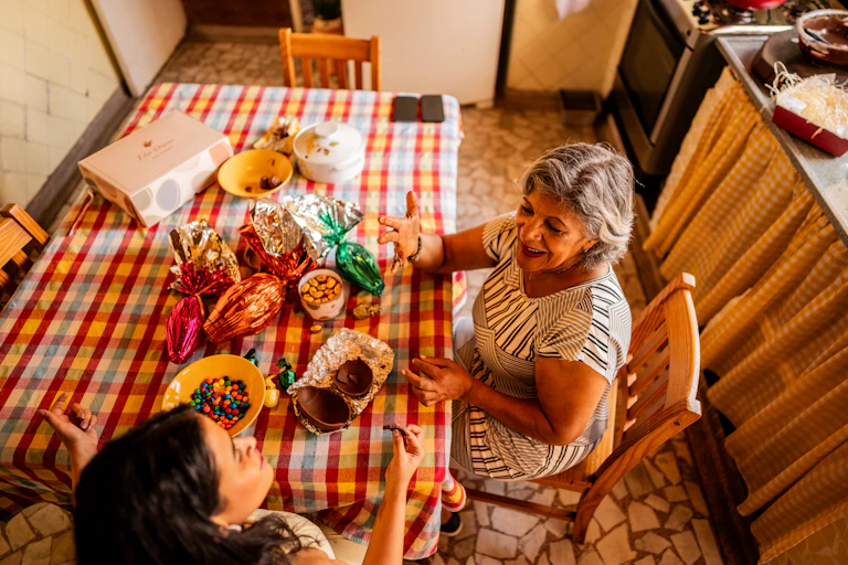 A grandmother and her granddaughter sitting at a table with bowls of Easter candy.