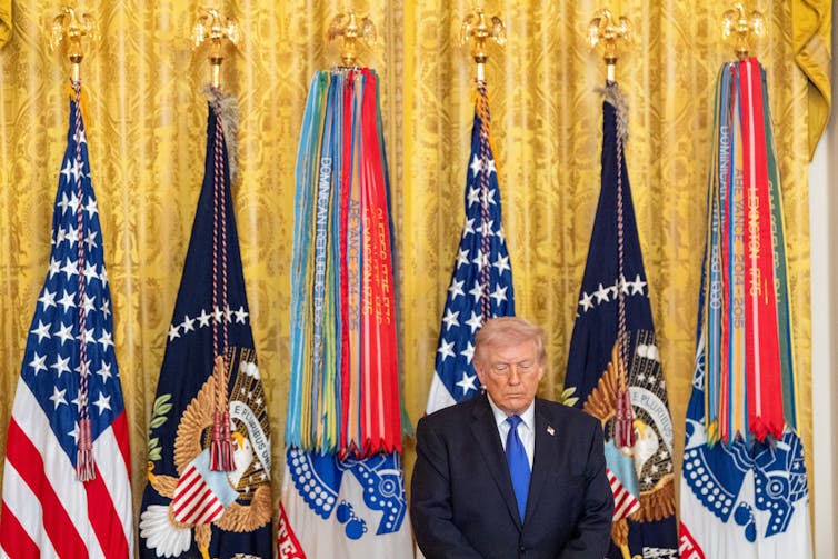 Cuando la guerra parece una profecía: cómo las narrativas estadounidenses del 'fin de los tiempos' enmarcan la guerra con Irán 1 Un hombre con traje se inclina con la cabeza gacha y los ojos cerrados.