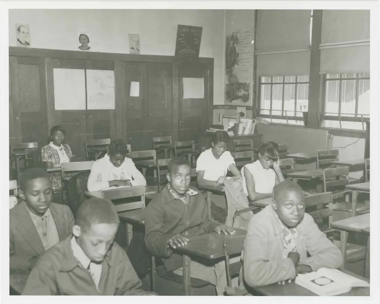 Boys in a classroom, sitting at desks.