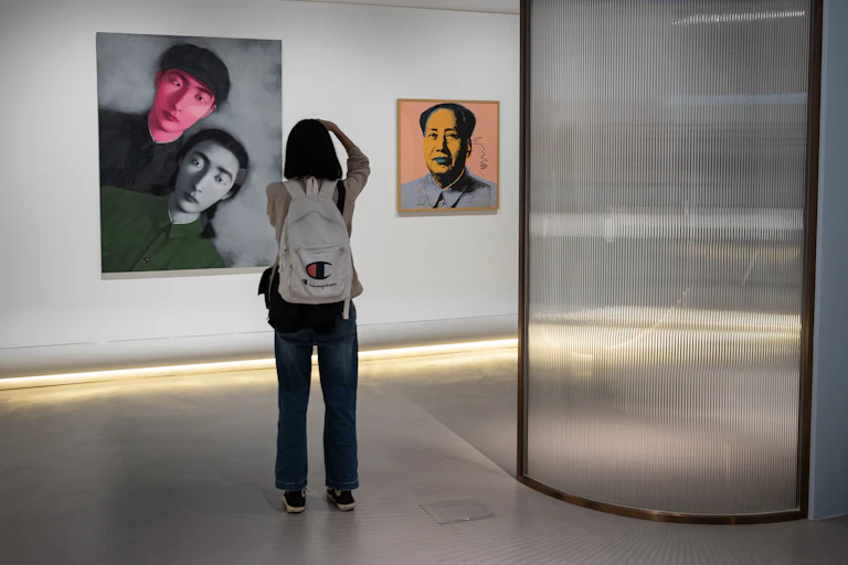 A woman takes pictures of art pieces during a Chinese art exhibition.
