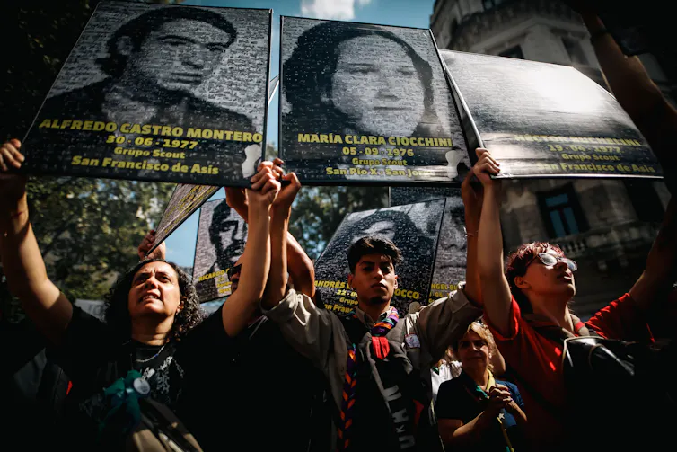 Demonstrators carry pictures of missing people in Argentina.