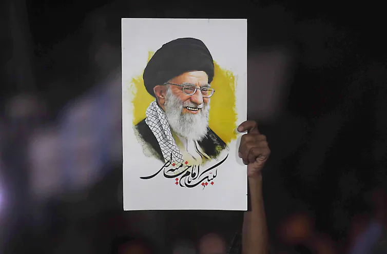 A person holds a picture of Ali Khamenei aloft at a rally.