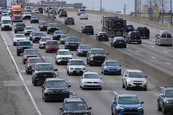 cars can be seen driving forward in several lanes on a major highway