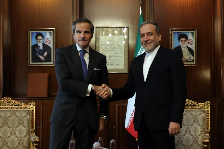 Abbas Araghchi shakes hands with Rafael Grossi inside a government office in Tehran.