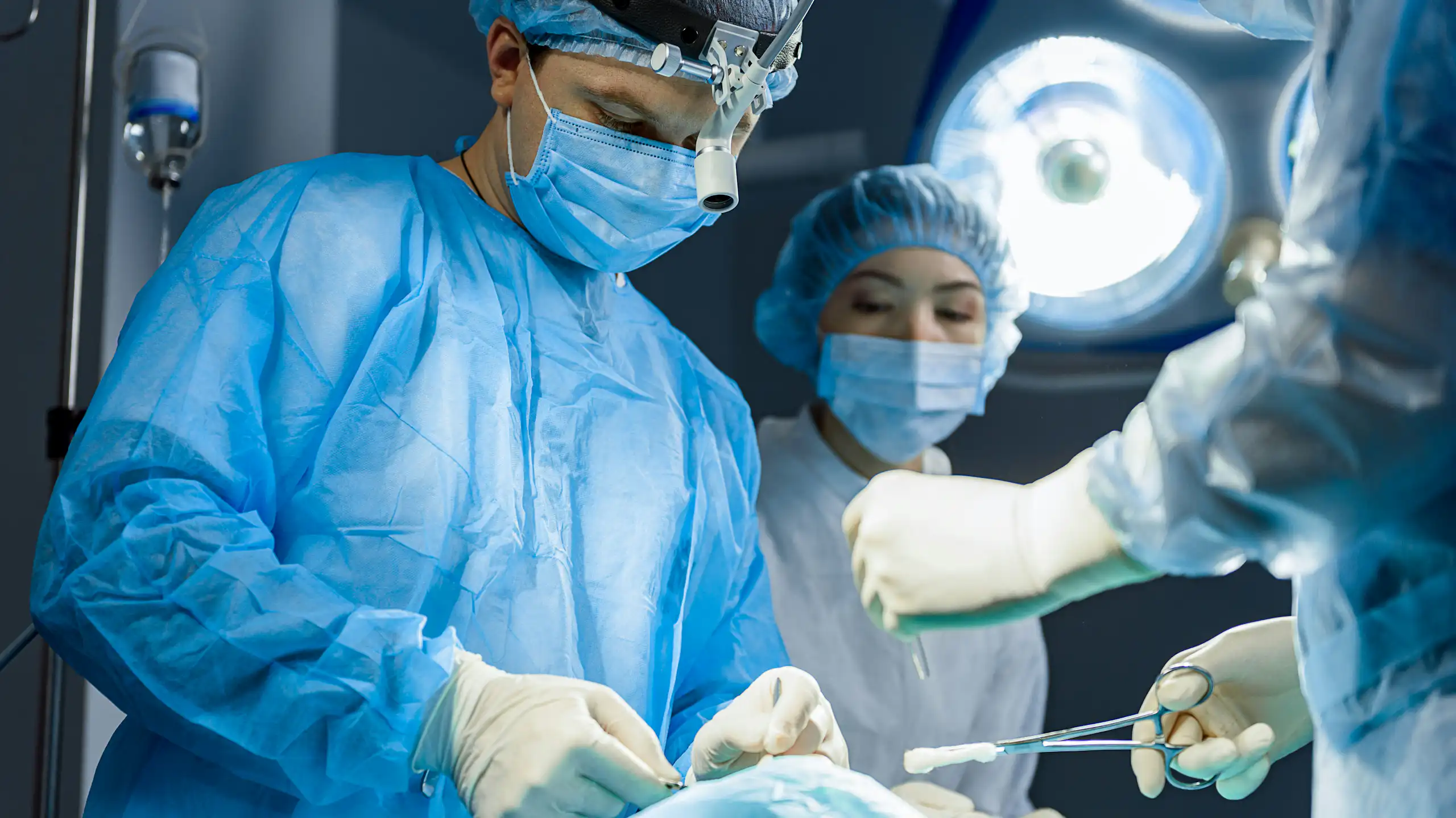 A surgeon operates on a patient in an operating room