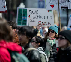 Personas que estudian para ser docentes hablan sobre la islamofobia y el racismo antipalestino en las escuelas de Ontario 3 Una persona en la manifestación tiene un cartel que dice