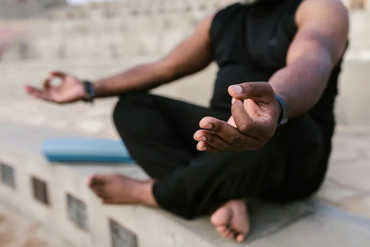 A person sitting in Sukhasana yoga pose