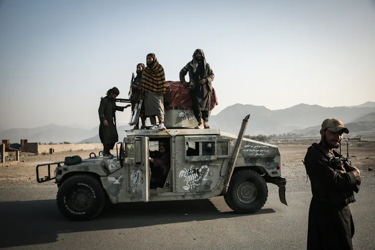 People stand on a vehicle.