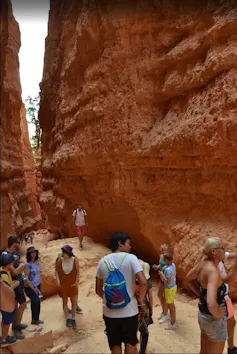 Este verano no estarás solo en los parques nacionales: disfruta de la compañía 2 Una vista de varias personas en un pequeño espacio bajo altas paredes de roca.