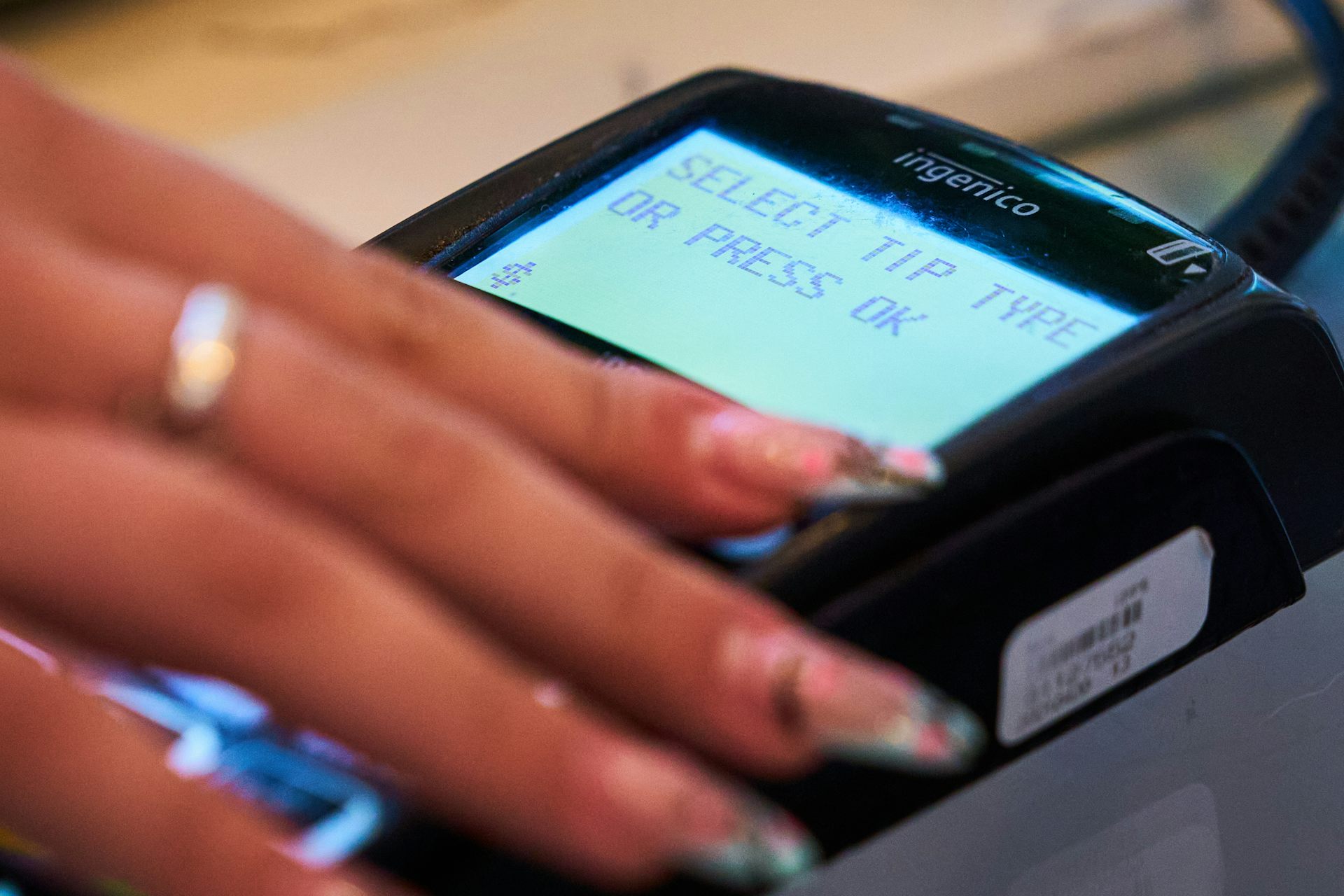 Primer plano de la mano de una persona en una máquina de tarjetas de punto de venta