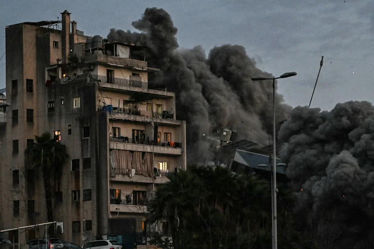 A black cloud rises next to an apartment bloc.