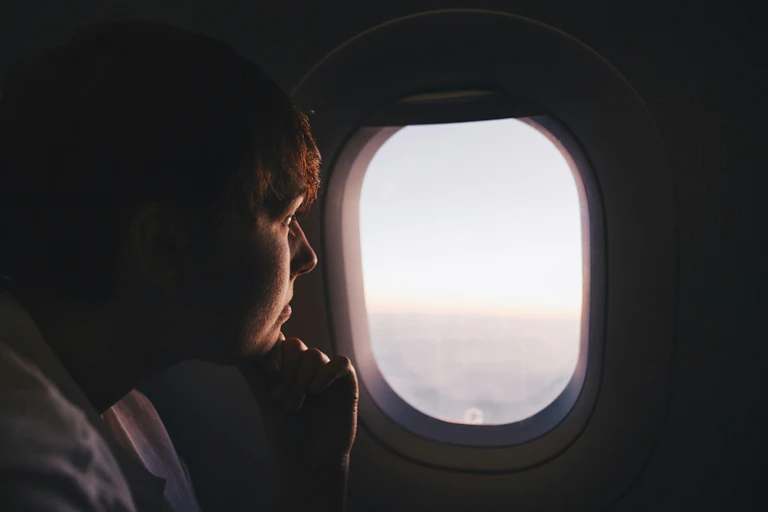 Man inside plane, looking out window