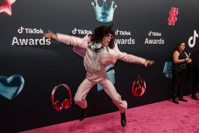Viral TikTok musician and singer, Mr. Fantasy dances on a red carpet.