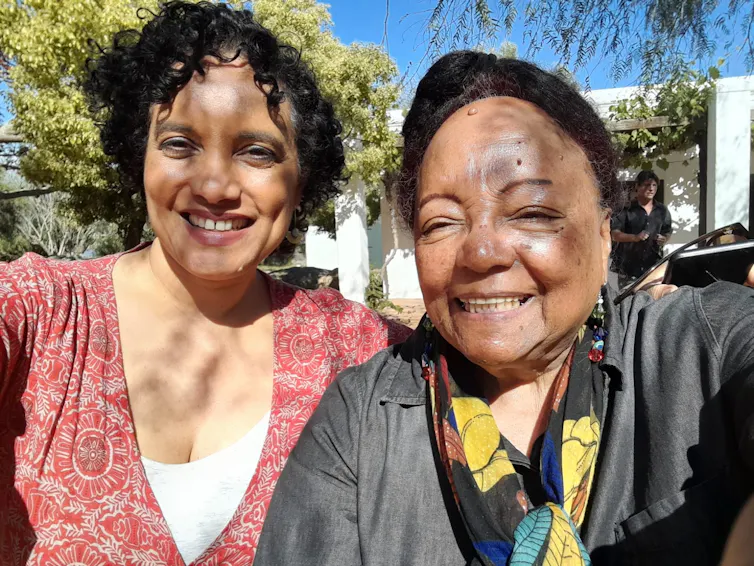 Two African women, one older, smile as they take a selfie.