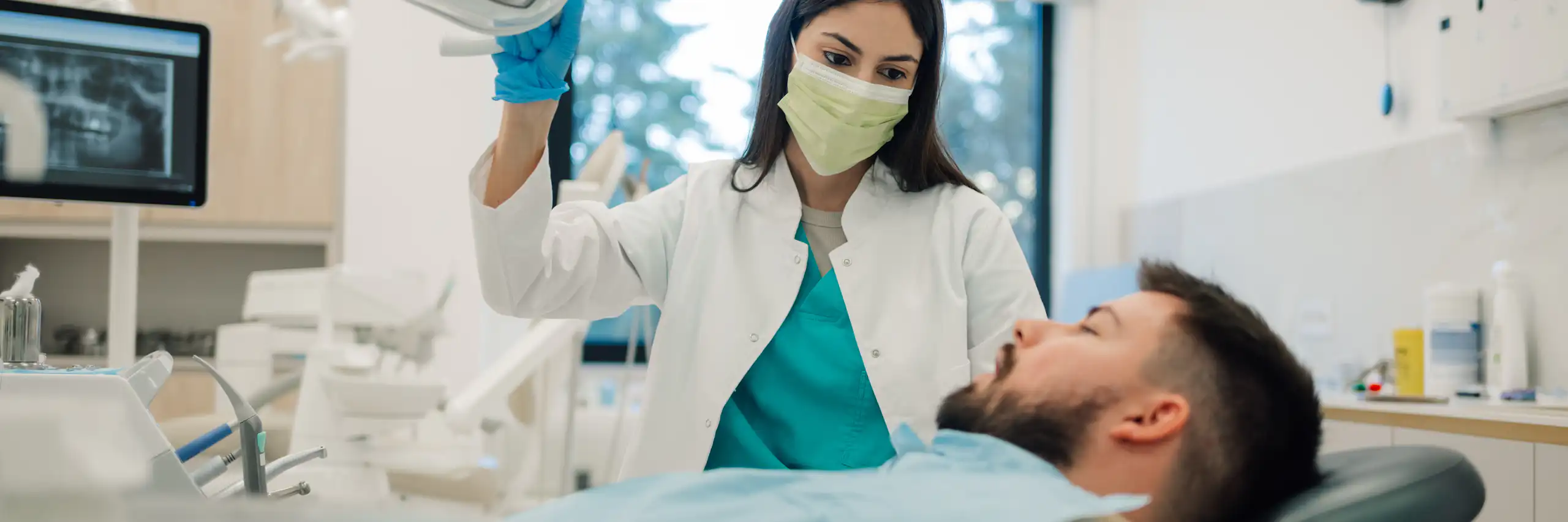 Une dentiste prend en charge un monsieur dans son cabinet.