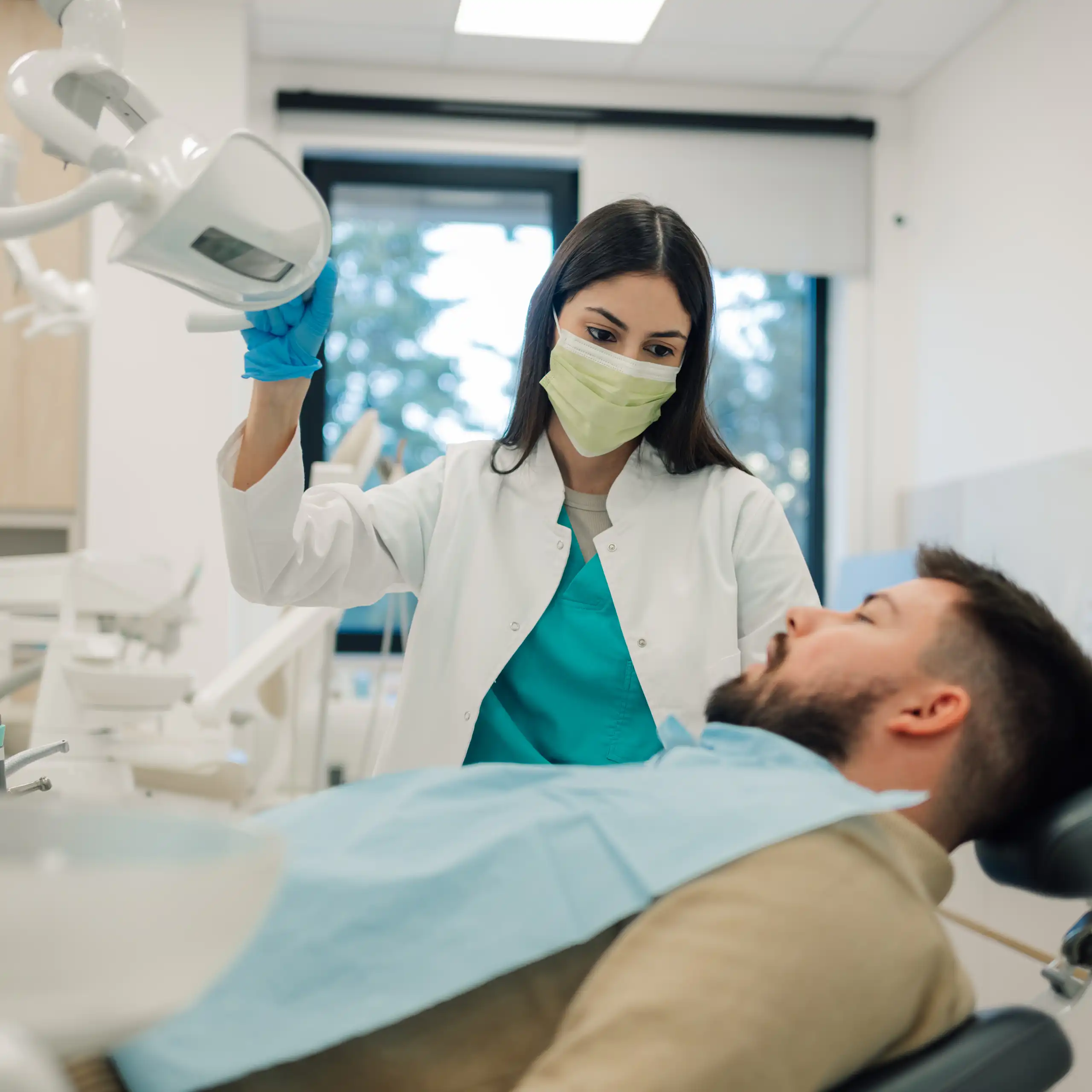 Une dentiste prend en charge un monsieur dans son cabinet.