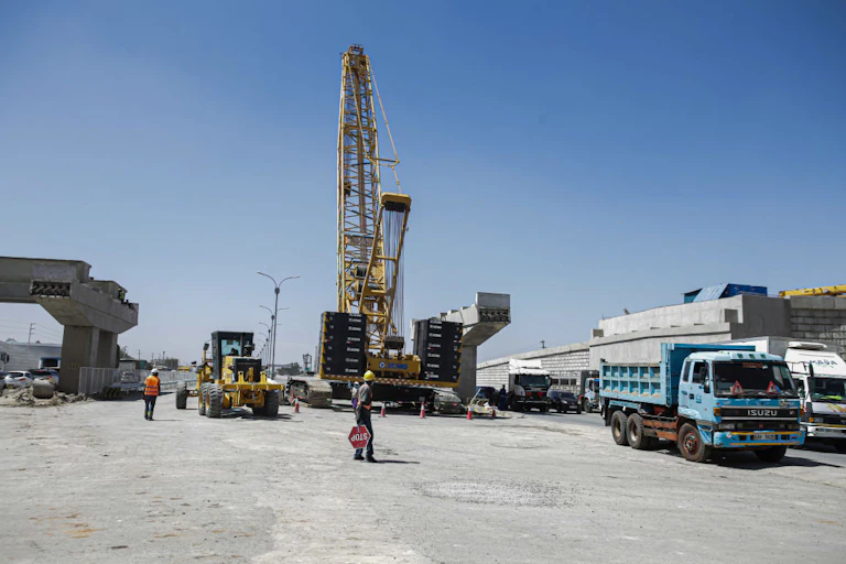 A worker helps direct traffic at a road construction site