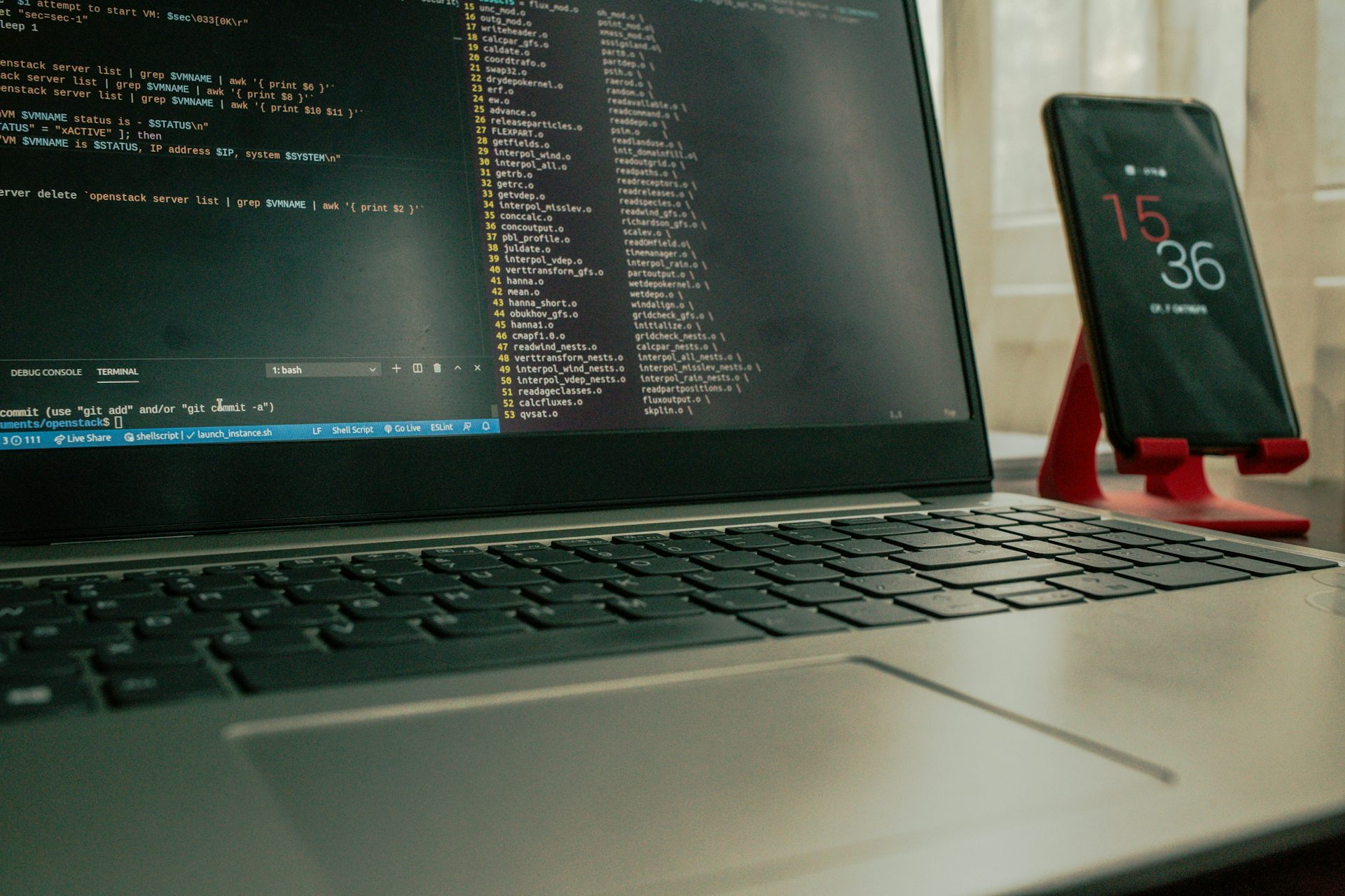A close-up of a laptop and a smart phone on a desk.