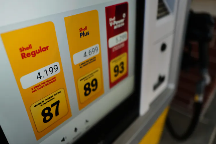 A close-up photo of a gas pump shows prices above $4 per gallon