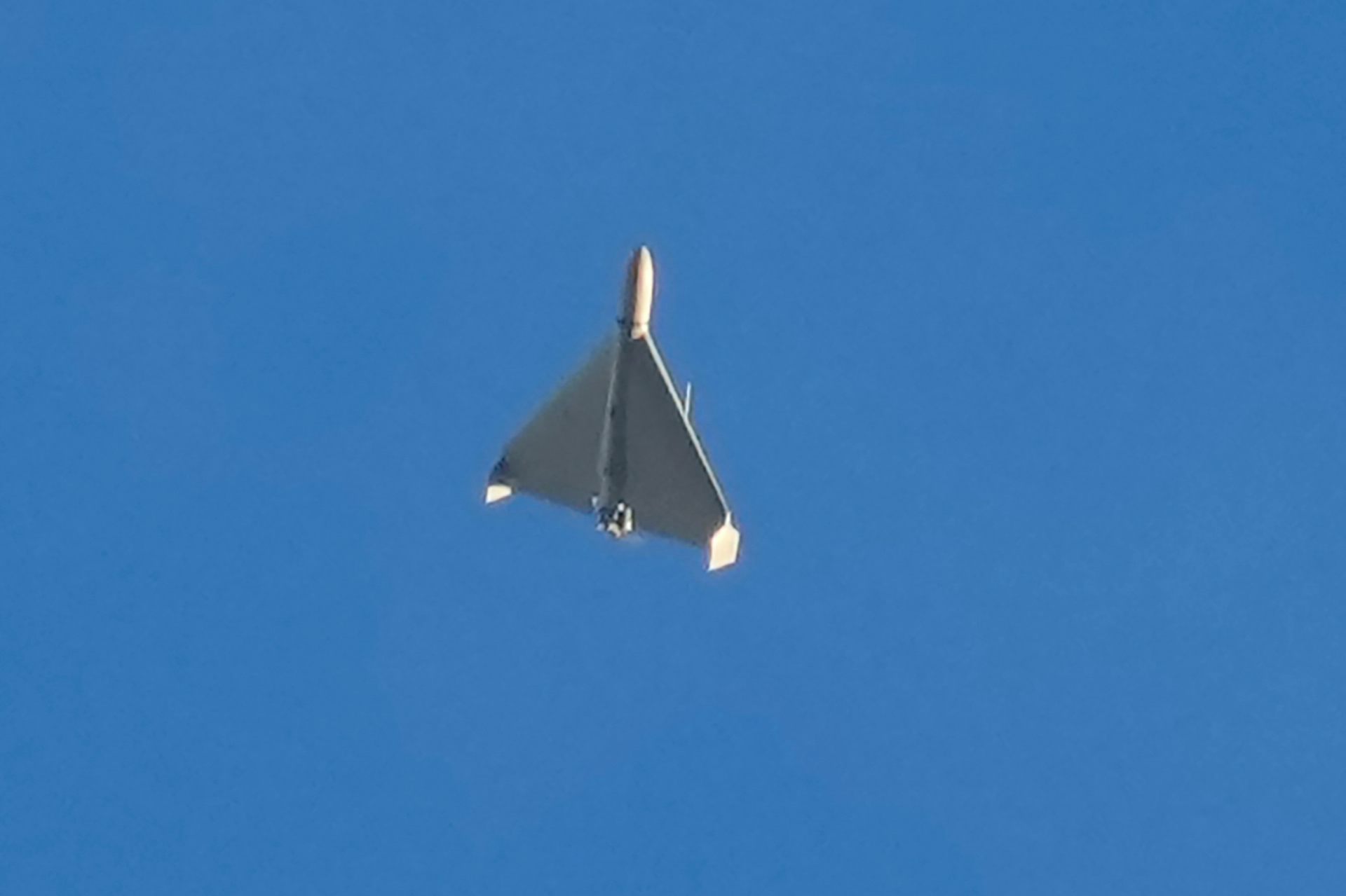 un pequeño avión de ala delta vuela hacia el cielo azul claro