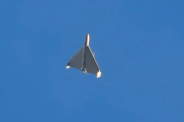 a small delta-wing aircraft flies against a clear blue sky