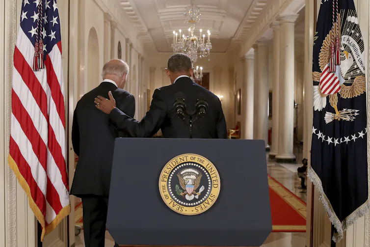 Two men walk away from a podium.