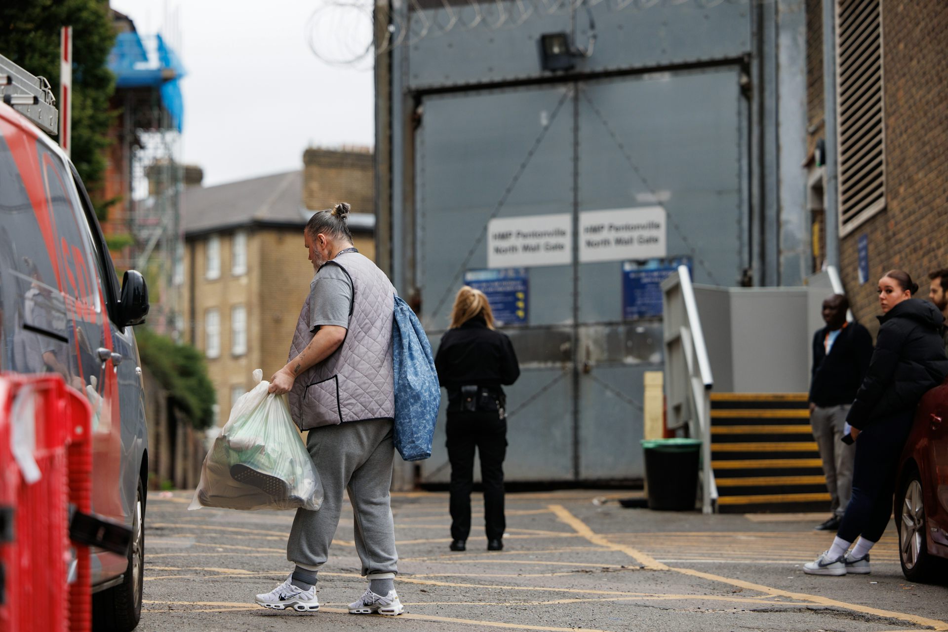 A prisoner carrying a plastic bag of belongings leaves HMP Pentonville