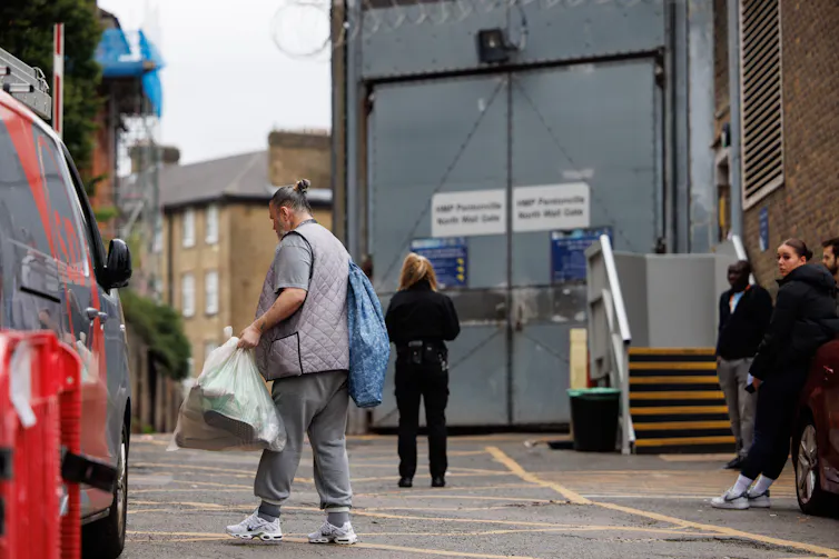 A prisoner carrying a plastic bag of belongings leaves HMP Pentonville