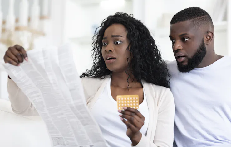 A woman and man react with shock to the instructions for her birth control pills.