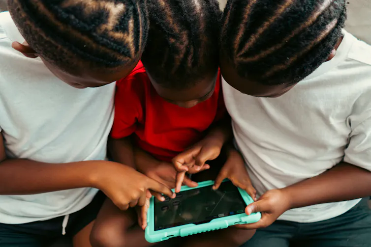 Three children using a tablet together