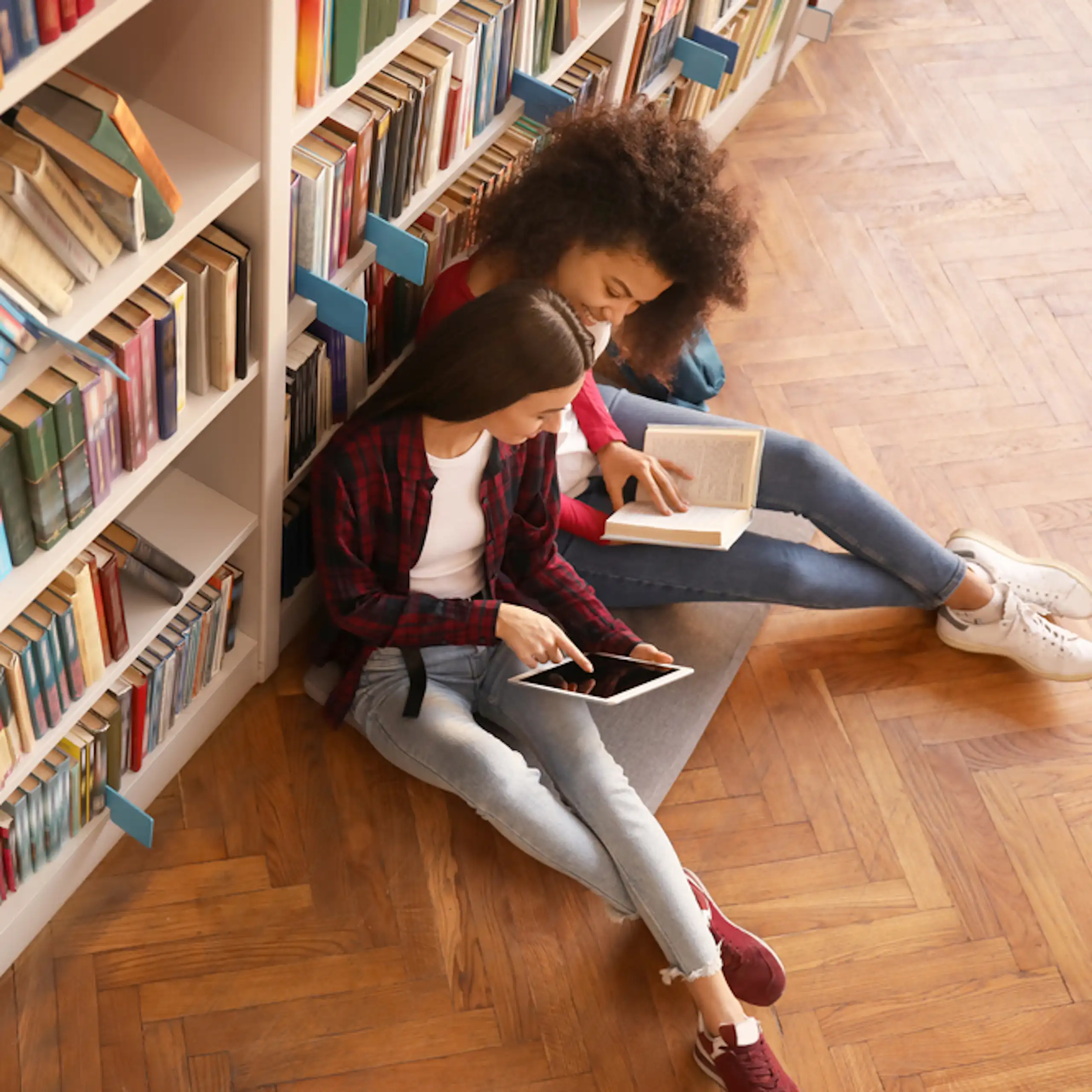 Deux étudiantes en train de lire dans une bibliothèque.