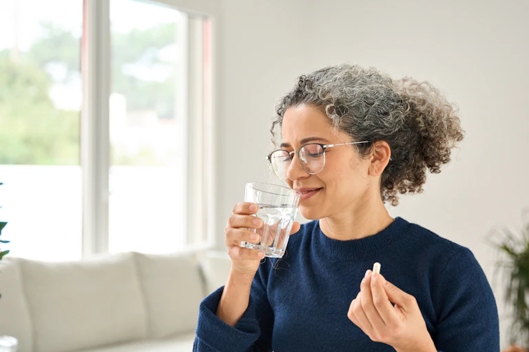 A woman taking a supplement.