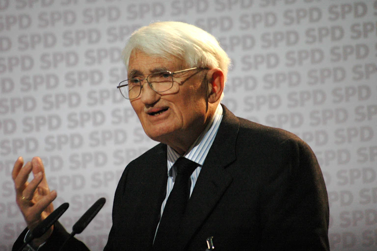 Habermas speaking at a podium
