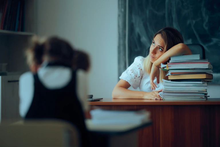 Une enseignante fatiguée devant une classe.