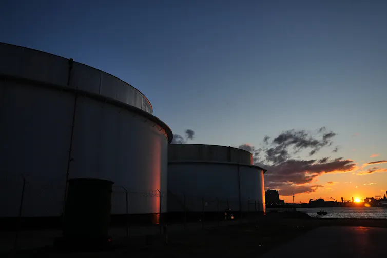 Crude oil storage tanks at sunset.
