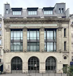 A grand building of about five stories with large windows and arches.