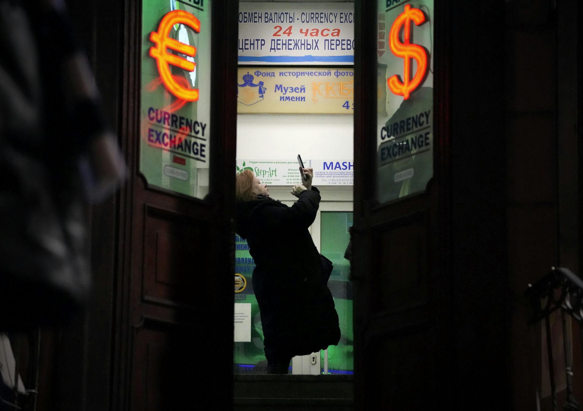 Una mujer está parada en la puerta de un edificio.