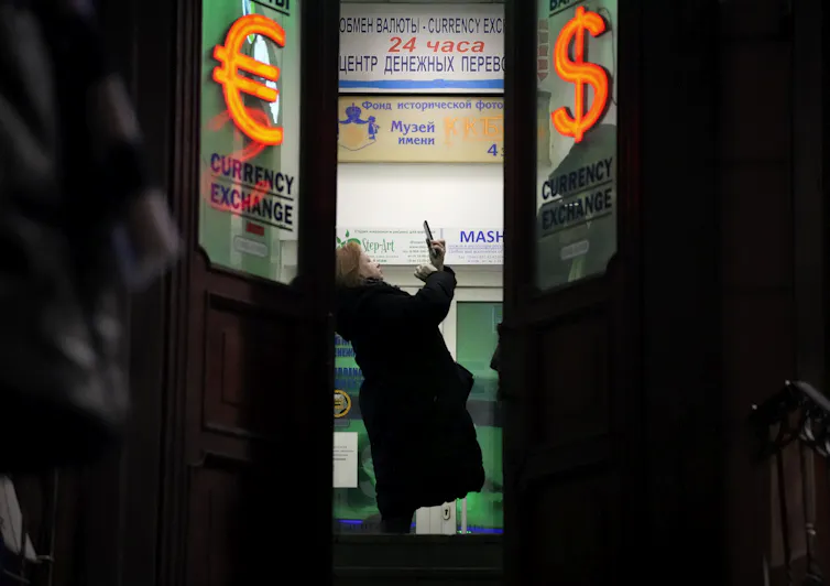Una mujer está parada en la puerta de un edificio.